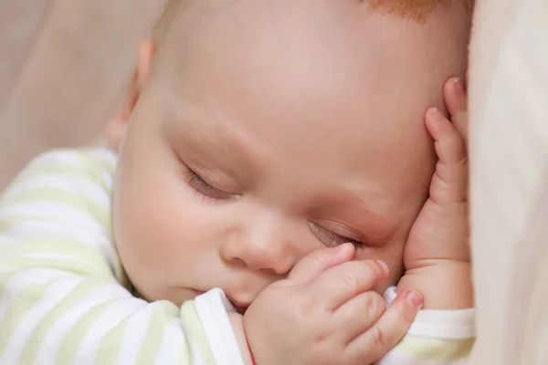 Sleeping baby in striped yellow sleep suit